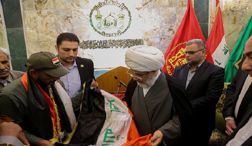 بالصور:  شهيد اعدمه الدواعش لرفعه العلم العراقي في الشرقاط، وعائلته يأتون بذلك العلم لمرقد الامام الحسين