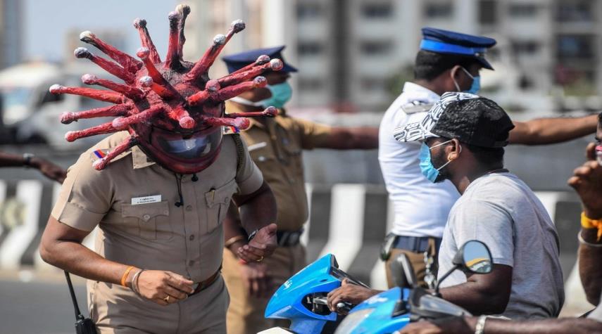 بالصور ... شرطي هندي يرعب المارة للبقاء في المنازل